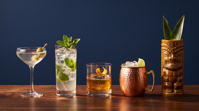 Coupe, highball, verre old fashioned, mug en cuivre et mug tiki alignés sur un comptoir Image