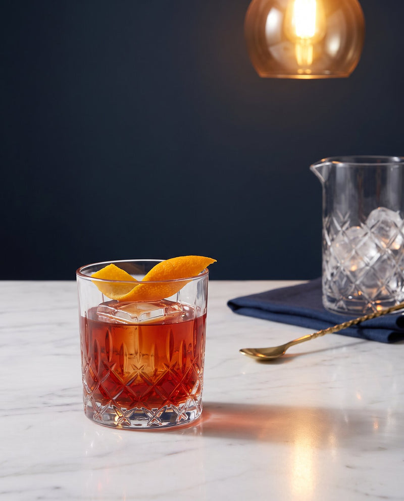 Negroni servi sur un gros glaçon avec un zeste d'orange