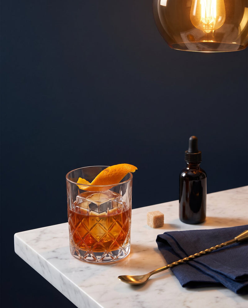 Old Fashioned servi dans un verre à whisky avec un zeste d'orange